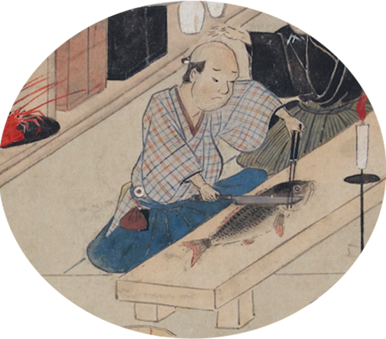 魚を捌いて宴席の料理を作っている男性